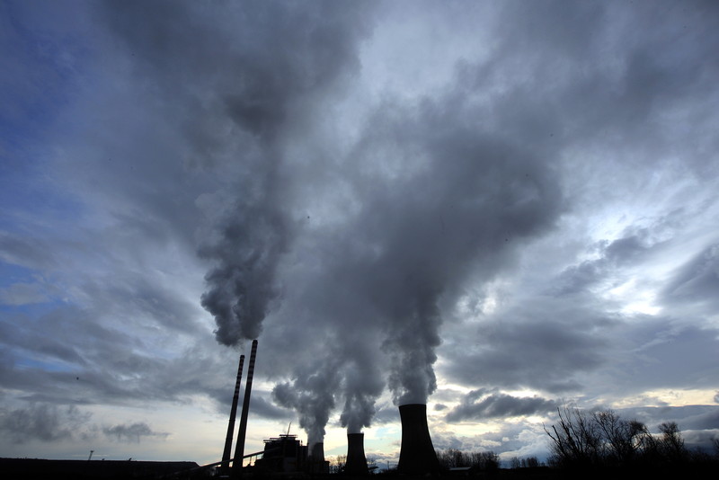 Steam billows from the cooling towers of a coal power plant