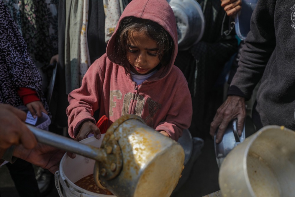 Internally displaced Palestinians receive food aid in Deir Al Balah
