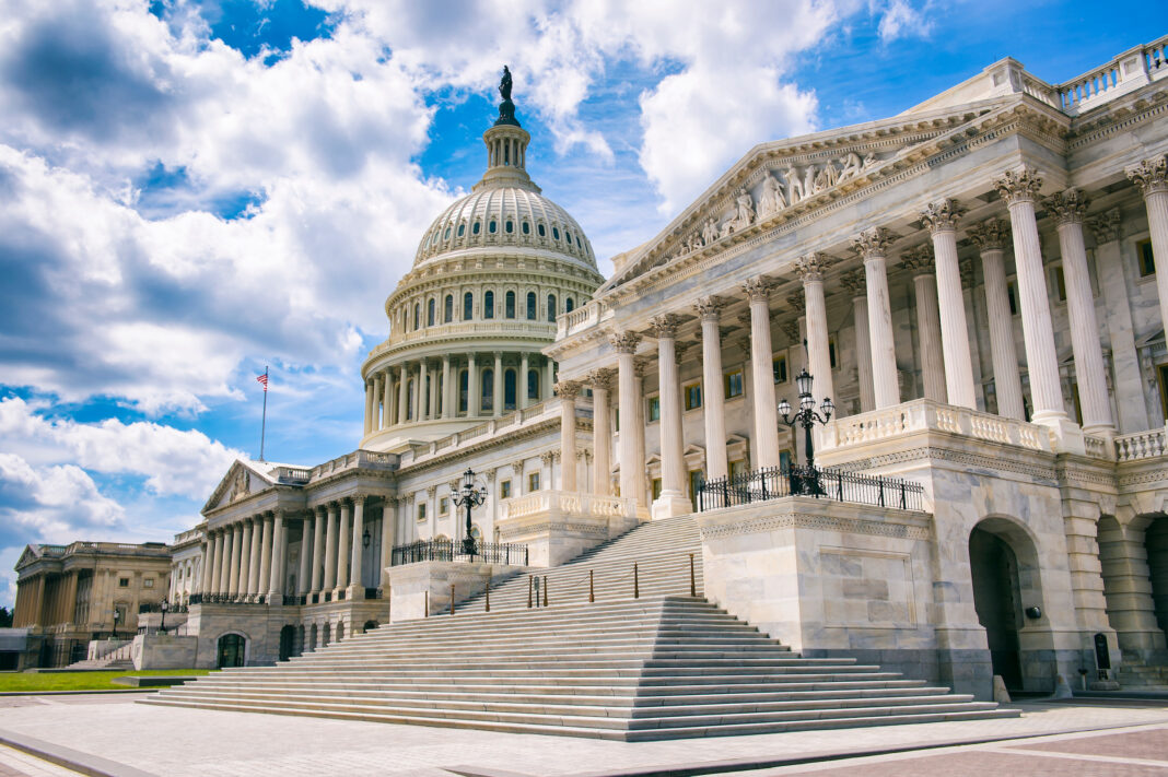 Bright mid-day view of the traditional neoclassical architecture of the Capitol Building’s dome, columns, and steps in Washington DC, USA